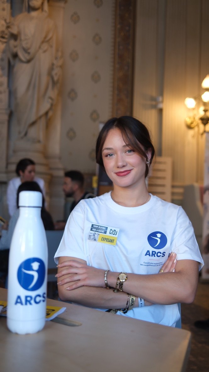 Une membre de l’équipe ARCS porte le tee-shirt du centre et accueille les visiteurs